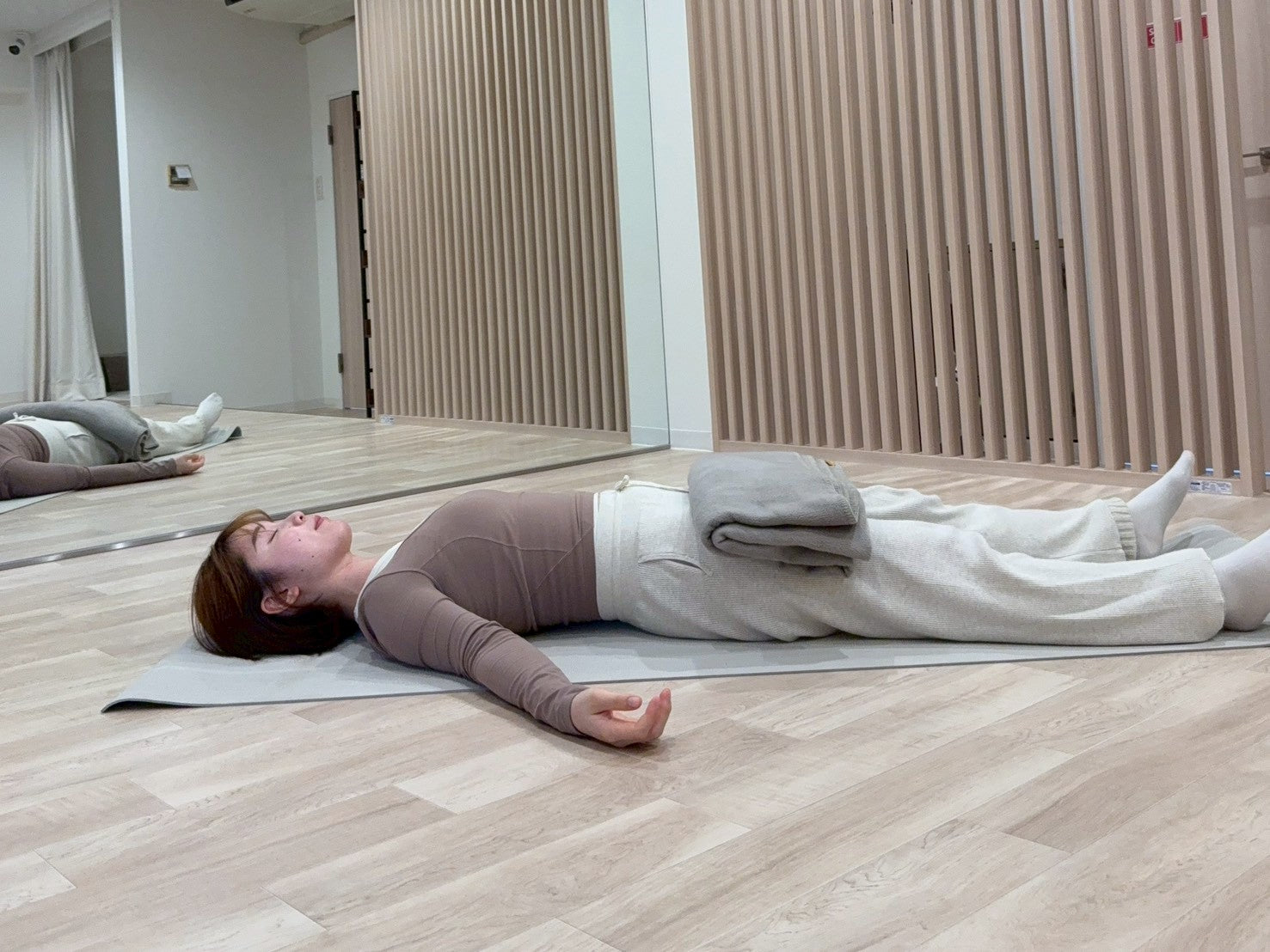 シャバーサナで太ももにヨガブランケットをのせている写真