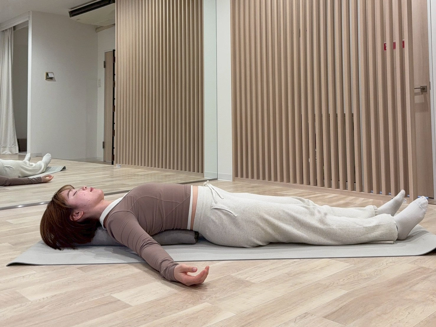 やさしい魚のポーズでヨガブランケットを背中の下に入れている写真