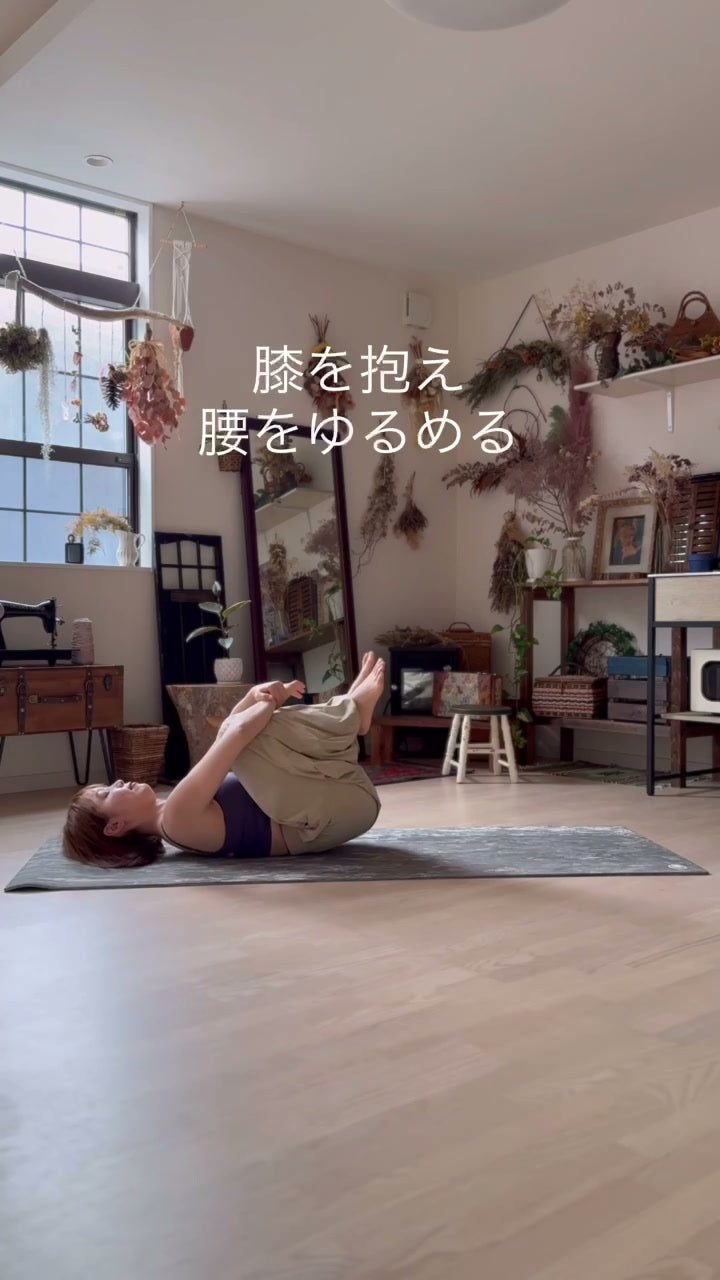 仰向けで両膝を両手で抱えて胸に近づける、腰と股関節をゆるめるポーズ